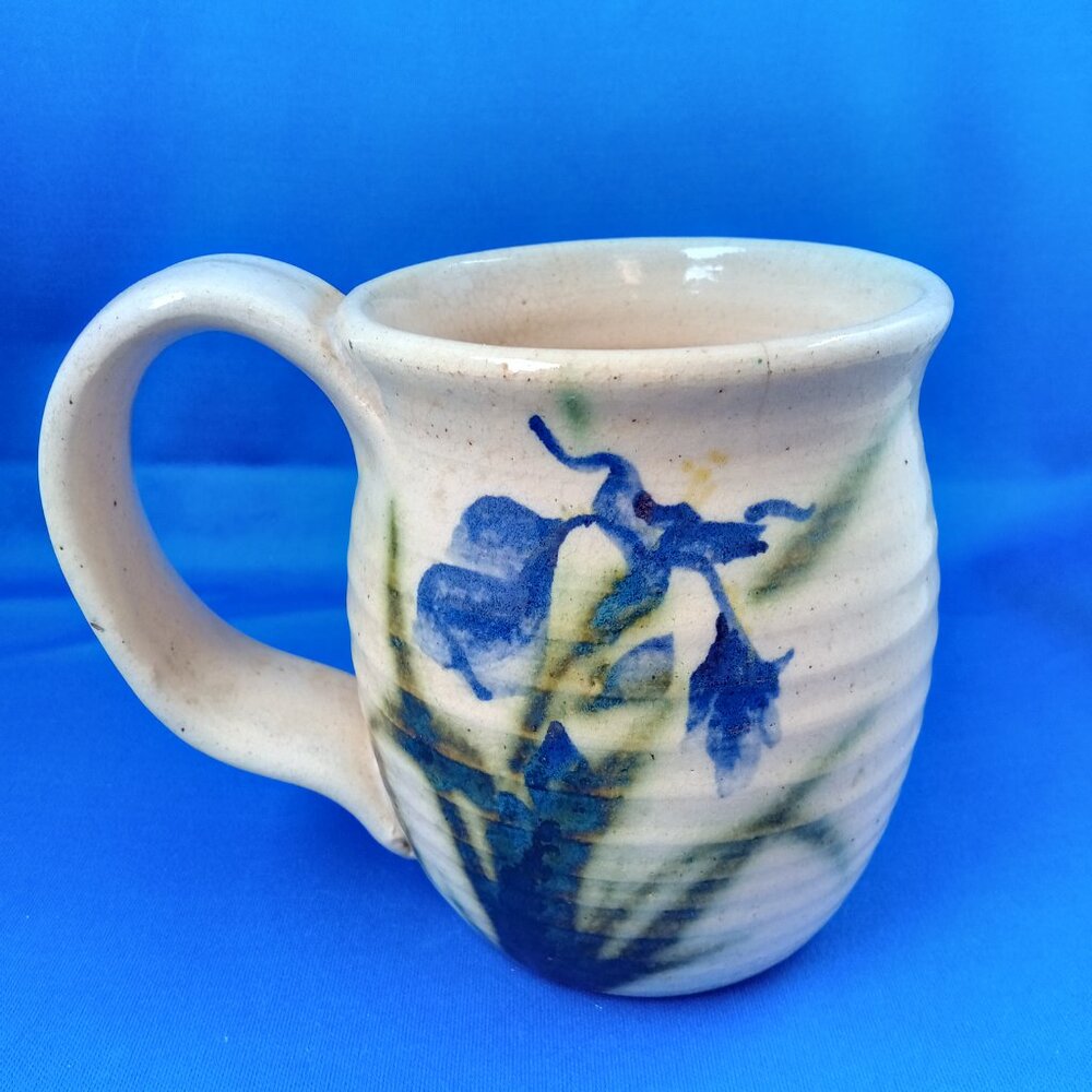 Handmade art pottery mug with blue iris design